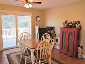 Dining room opening onto a sunny deck of this cozy coastal cape in South Thomaston on the  coast of Maine